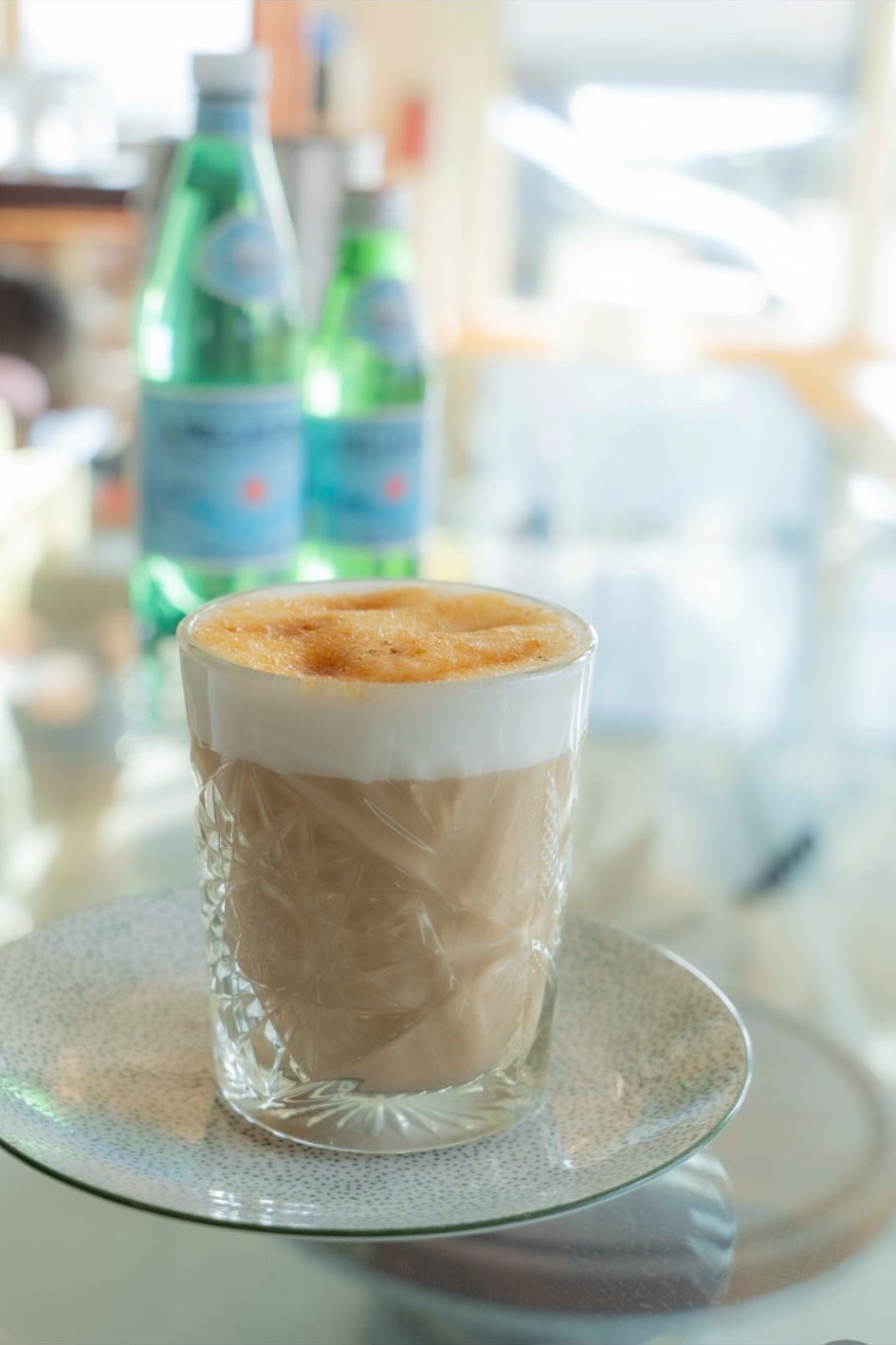 A cortado in steam and morning light against the front window on Humphrey Street.